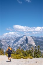 A young man walking along Sentinel Dome looking at Yosemite National Park. United States