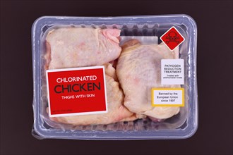 Concept for chlorinated chicken with pack of raw chicken thighs with warning label