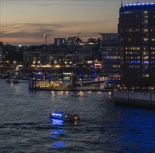 Harbour cruise ship and Elbe Philharmonic Hall illuminated in the evening