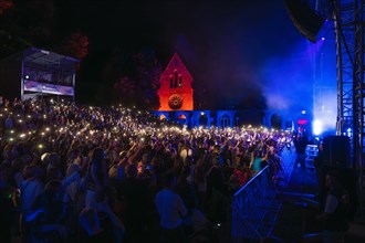 Crowd with lights at Live Klostersommer Festival in Historic Monastery