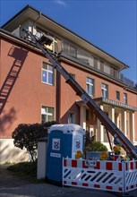 Rotating industrial construction ladder on a residential building