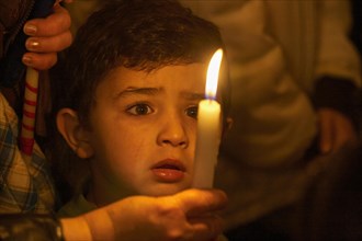 Little boy looking spellbound at a candle