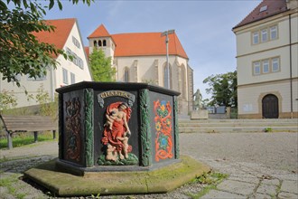 Abbey fountain built in 1713 with relief and painting and late Gothic abbey church