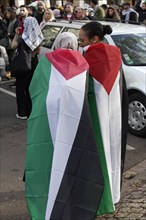 Demo participants draped in Palestine flag