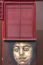 Mural of a girl's head under a barred window