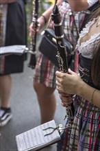 Musician holding her clarinet and sheet music ready to play