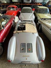 Porsche 550 Spyder Replica stands for reconditioning in large hall behind it other vintage VW Beetle Golf