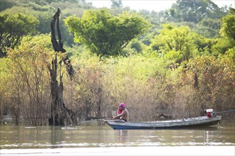 Brazilian man sitting in a boat fishing in the Rio Amazonas