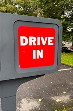 Red sign with white lettering Drive In at entrance of fast food restaurant Burger King