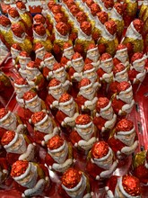 Display in shelf of wholesale of chocolate Father Christmas Father Christmas colour red of red staniol paper of chocolate in brand merci arranged like army of Father Christmas