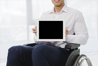 Close up businessman sitting wheelchair showing digital tablet with black screen