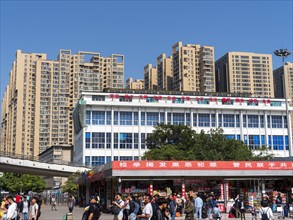 Station forecourt with passers-by and high-rise buildings