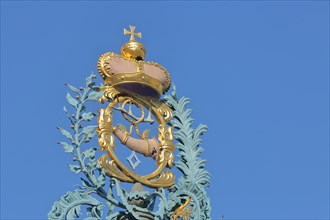 Golden crown with imperial orb and post horn with ornaments at the market fountain