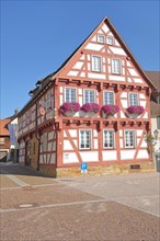 Red half-timbered house with floral decoration