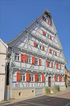 Grey half-timbered house with red shutters