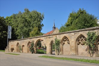 Historical stone wall with archways and monastery courtyard