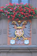 City coat of arms with double-headed eagle and floral decoration on the town hall
