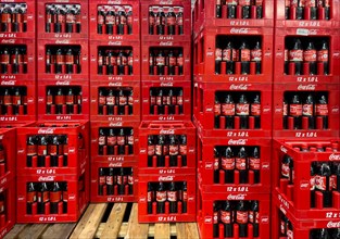 Display of in wholesale on pallet wooden pallet side by side one above the other stacked high red boxes con Coca Cola each with 12 twelve 1 litre bottle one litre bottle of plastic with sugary caffein...