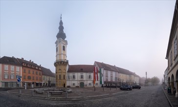 Morning fog on the main square with the town hall tower