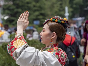 Tibetan young woman with festive hair decoration and splendid clothing