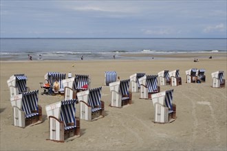 Beach chairs and tourists on the sandy beach