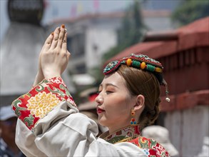 Tibetan young woman with festive hair decoration and splendid clothing