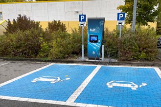 Charging station for e-car in front of supermarket of supermarket chain Aldi Sued next to it traffic sign parking spaces two e-cars can be charged