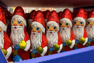Display in shelf of wholesale of chocolate Father Christmases Nikolaus Nikolaeuse colour red of red staniol paper of chocolate in brand Klett arranged like army of Father Christmas