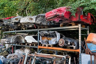 Scrapped bodies of car Porsche 911 from 60s 70s stored in high rack in outdoor area waiting for for restoration