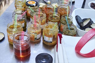 Opened tasting jars with different jellies and jams