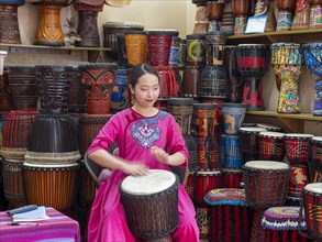 Young Chinese woman drumming and singing