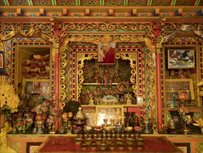 Tibetan prayer room with Dalai Llama image and wood carvings in Jiabe village
