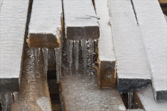 Stack of 2 x 4 pieces of lumber covered in ice