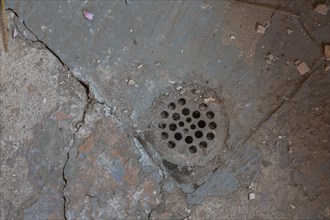 Metal drain in damaged concrete floor