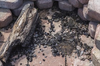 Paving stone firepit with partially burnt log and coals
