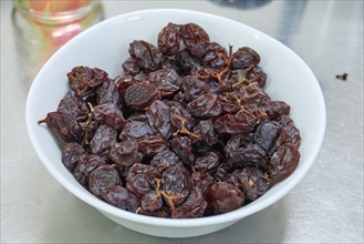 Dried dates in white porcelain bowl