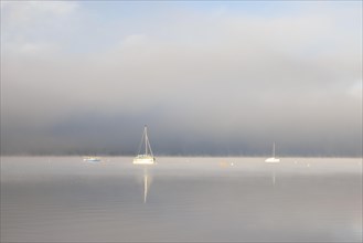 Fog over Lake Constance on an autumn morning with boats