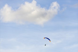 Paraglider in front of cloudy sky