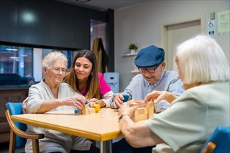 Elderly people and a nurse in a nursing home sharing skills games