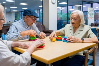 Aged people in a nursing home sharing skills games sitting on a table together