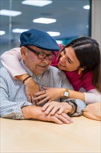 Vertical photo of a tender moment of a nurse embracing a elder man in a geriatric