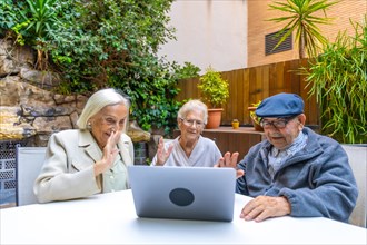 Introducing technology to senior people in a nursing home while three people using laptop