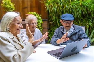 Happy senior people using laptop to have fun in a geriatric