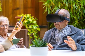 Virtual reality experience for elder people in a geriatric sitting on a garden