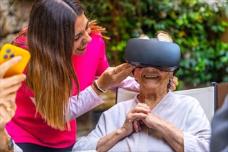 Nursing supervising a senior woman using Virtual Reality goggles in a geriatric