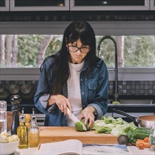Woman reading recipe while preparing food