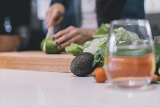 A woman chopping a vegetable in her kitchen. Copy space