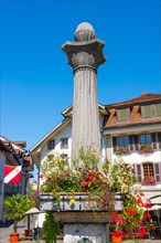 Medieval City Square in Old Town with a Statue with Flowers in Thun in a Sunny Day in Bernese Oberland
