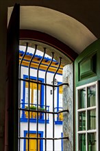 Historic colonial style house seen through the window of a church in the city of Mariana in the state of Minas Gerais