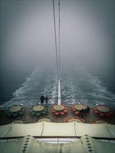 Stern of a cruise ship in the fog in a gloomy atmosphere